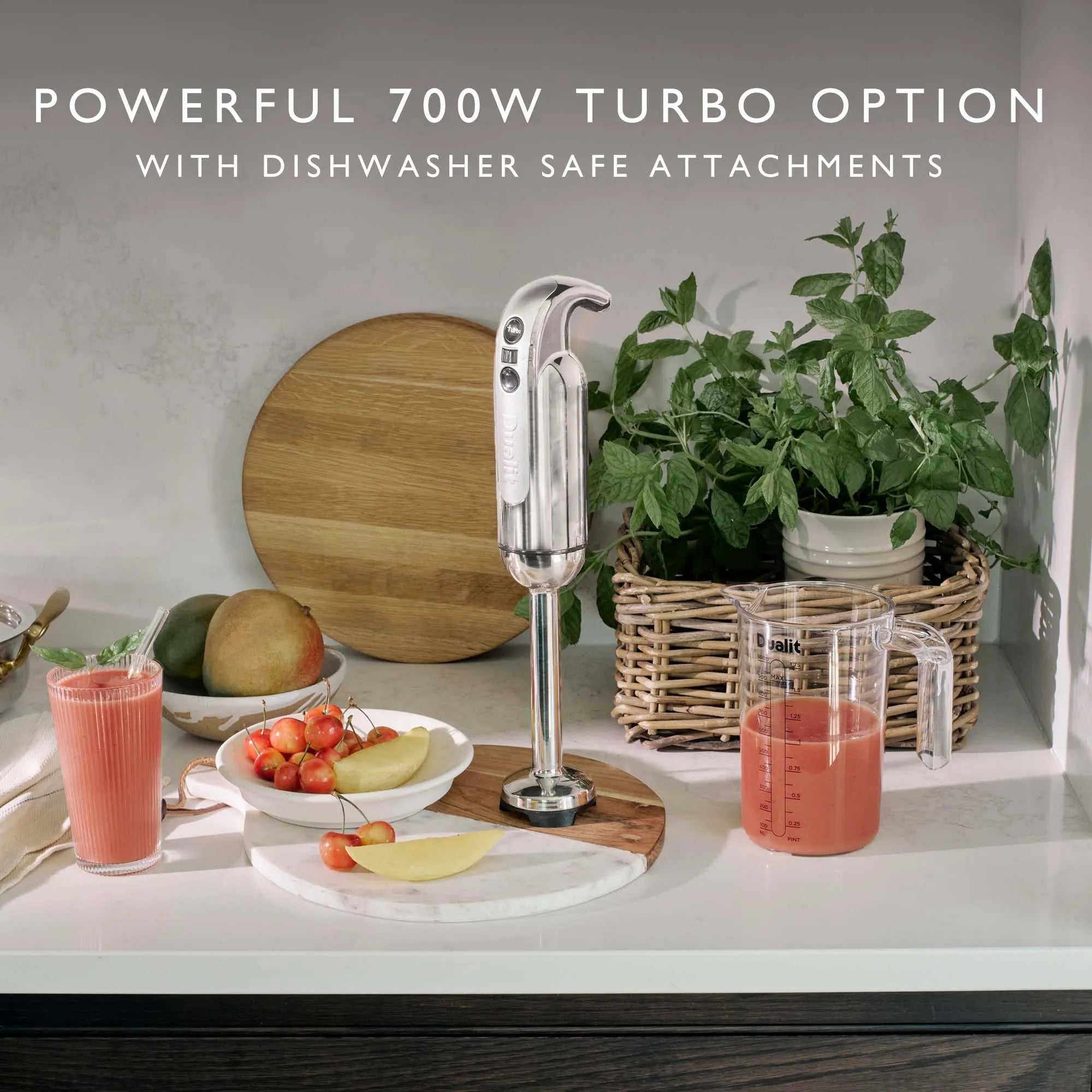 Kitchen scene with a blender on a counter, fruits, and a plant with "Powerful 700W Turbo Option with Dishwasher Safe Attachments" text.