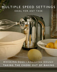 Dualit hand mixer next to a bowl with text "Multiple Speed Settings Ideal for Any Task" in a kitchen setting