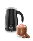 Black Dualit milk frother with a glass of hot chocolate and marshmallows on a white background