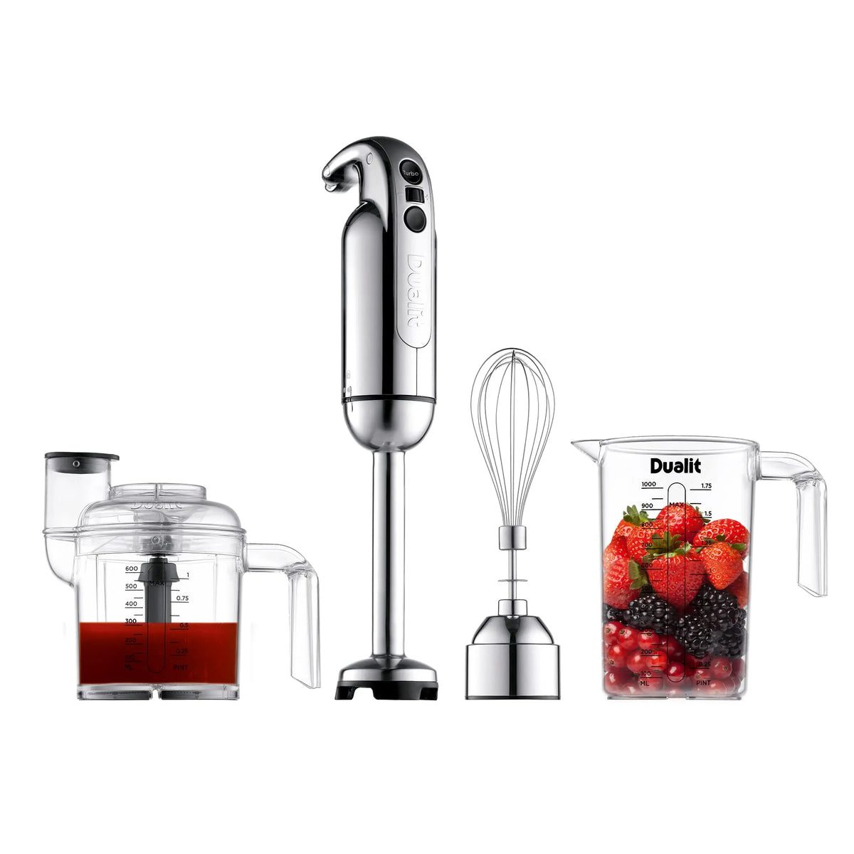 A stainless steel hand blender set with a tall immersion blender, a whisk attachment, a clear blending cup containing red liquid, and a clear measuring cup filled with strawberries, blackberries, and redcurrants on a white background.
