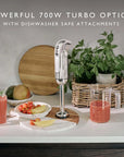 Kitchen scene with a blender on a counter, fruits, and a plant with "Powerful 700W Turbo Option with Dishwasher Safe Attachments" text.