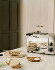 Silver toaster on a kitchen counter with bread and butter