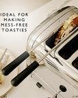 A stainless steel 4-slice toaster with black handles shown on a light countertop, with toast inside one slot and a plate of toast partially visible on the left. Text on the image reads 'IDEAL FOR MAKING MESS-FREE TOASTIES'.