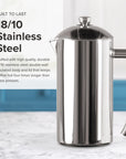 Stainless steel French press on a marble surface with text about its material and durability.