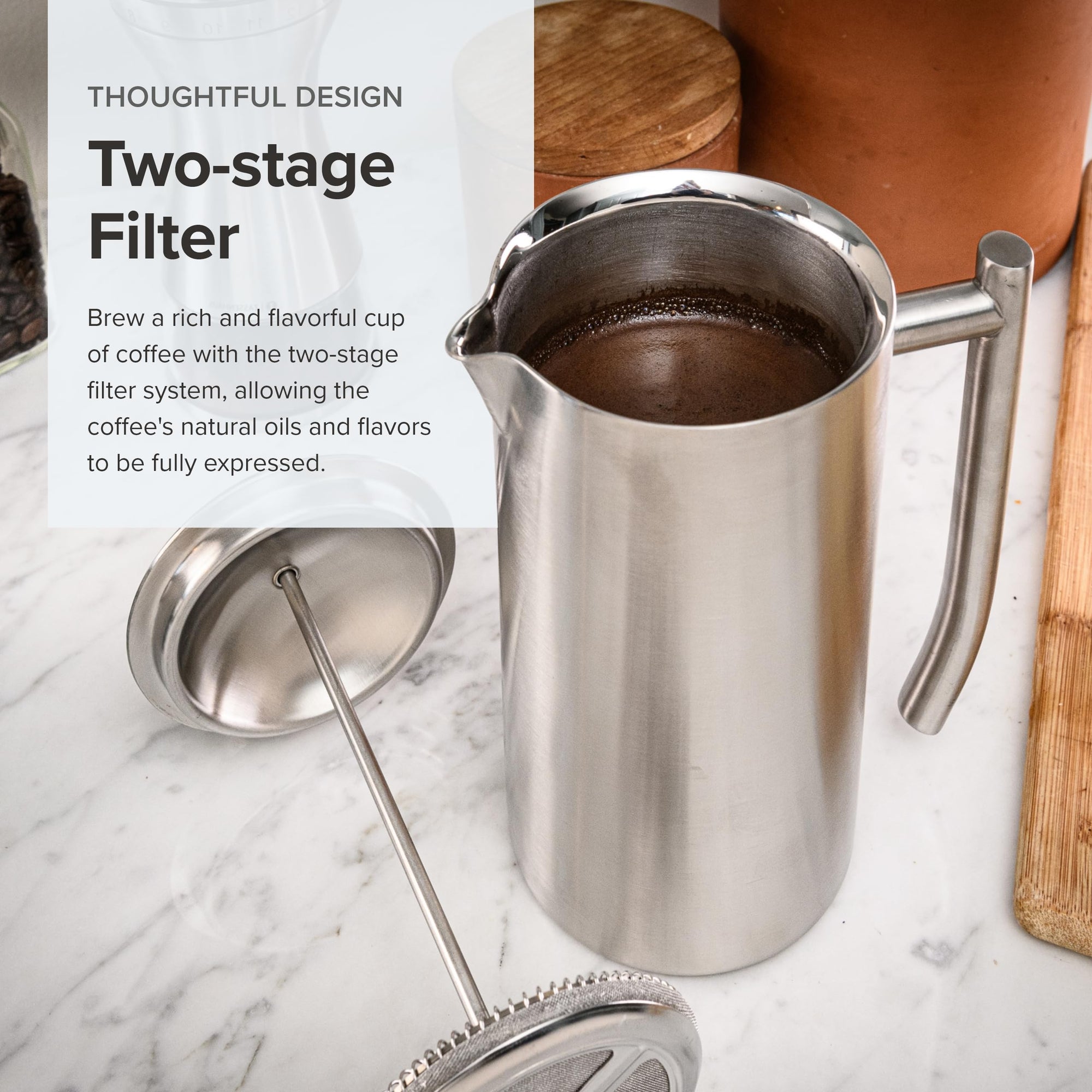Stainless steel coffee filter pitcher with text on a marble surface