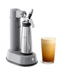 A slate grey Electric Nitro Cold Brew Coffee & Cocktail Maker Machine next to a glass of creamy coffee displayed on a white background