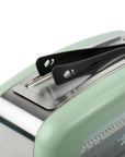Green toaster with a black tong displayed on top
