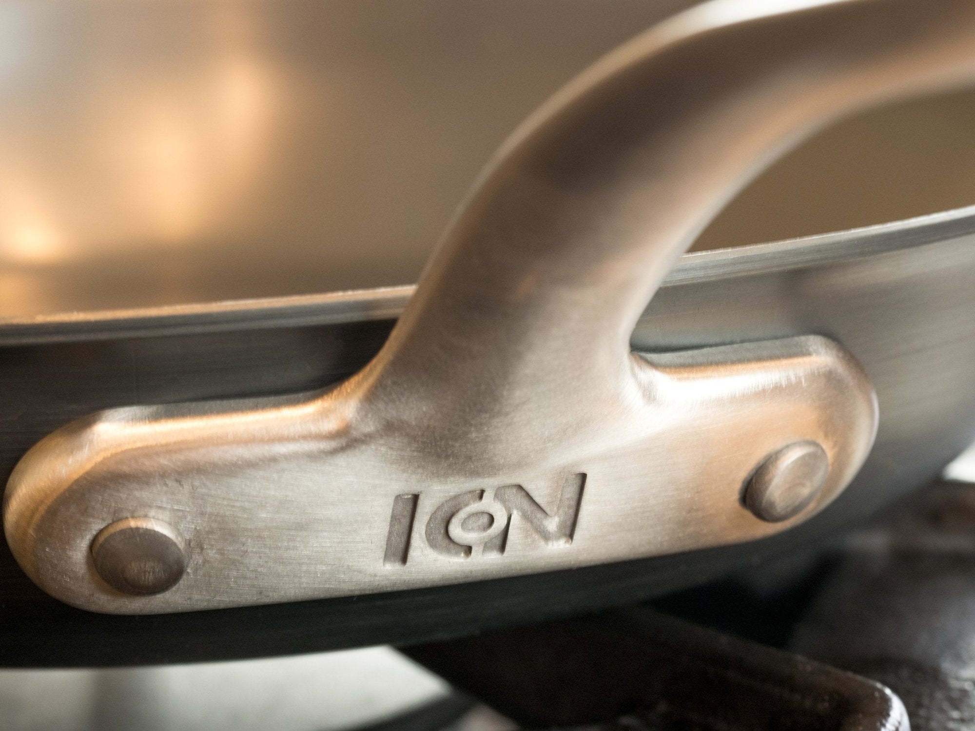 Close-up of a metal handle with 'ION' branding on a pot.