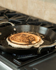Pan on a stove with a tortilla cooking inside