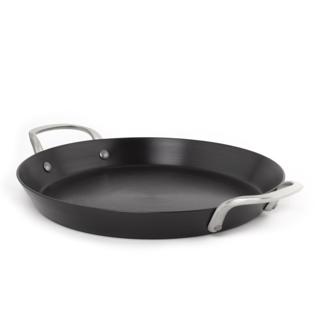 Black frying pan with silver handles on a white background