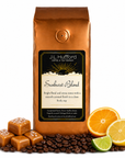 1 lb Sunburst Blend coffee beans bag with coffee beans, salted caramel blocks, and citrus items in front displayed on a white background