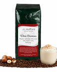 1 lb J.L. Hufford White Christmas coffee bag with coffee beans, hazelnuts, and white cocoa drink on a white background