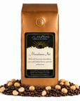 1 lb J.L. Hufford Macadamia Nut Coffee with coffee beans and macadamia nut in front displayed on a white background