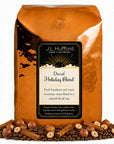 5 lb Decaf Holiday Blend coffee beans bag with coffee beans, hazelnuts, and cinnamon sticks in front displayed on a white background
