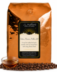 5 lb J.L. Hufford Indian Monsoon Mailbar AA coffee bag with coffee beans and clear bowl of syrup on a white background