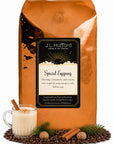 5 lb J.L. Hufford Spiced Eggnog coffee bag with coffee beans, glass of eggnog, pine needles, and cinnamon sticks on a white background
