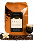 5 lb J.L. Hufford Vanilla Irish Stout coffee bag with coffee beans, vanilla sticks, and a glass of Irish Stout on a white background