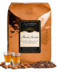 5 lb J.L. Hufford Almond Amaretto coffee bag with 2 shot glasses, almonds, and coffee beans on a white background