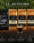 J.L. Hufford espresso bean package with coffee bags and a glass of coffee on a dark surface.