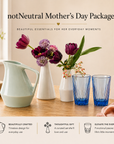Table with decorative notNeutral items including a pitcher, vases, and glasses with a 'notNeutral Mother's Day Package' text.