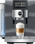 Front view of a Jura Z10 fully automatic espresso machine in dark gray and silver, shown with a glass of layered latte macchiato on its drip tray.
