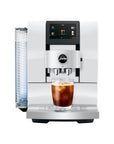 White coffee machine with a glass of iced coffee on a white background