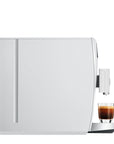 White coffee machine with a glass of espresso on a white background