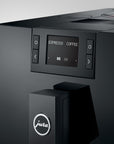 Black coffee machine with digital display and Jura logo on a light gray background