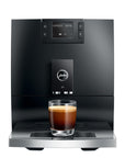 Black coffee machine with a glass of espresso on a white background