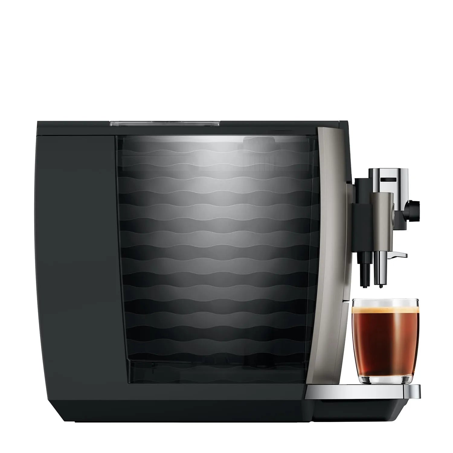 A modern automatic coffee machine in black and silver, shown with water tank and a glass of espresso on its drip tray against a plain white background.
