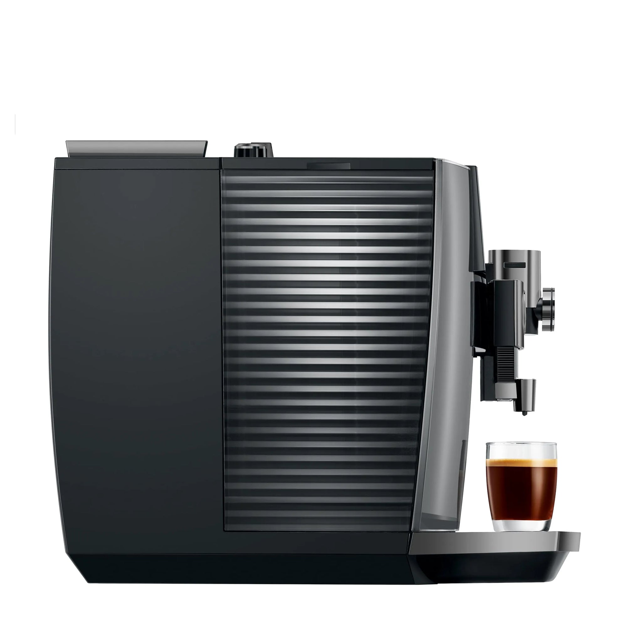 A sleek black and dark gray coffee machine with a ribbed water tank, shown on a plain white background with a small glass of espresso underneath the drip tray.
