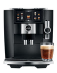 Black and silver Jura coffee machine with a glass of coffee on a white background