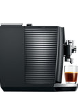 Black coffee machine with a glass of coffee on a white background