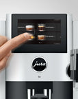Jura coffee machine with a hand interacting with the touchscreen display.