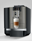 Modern coffee machine with a glass of layered coffee on a light gray background