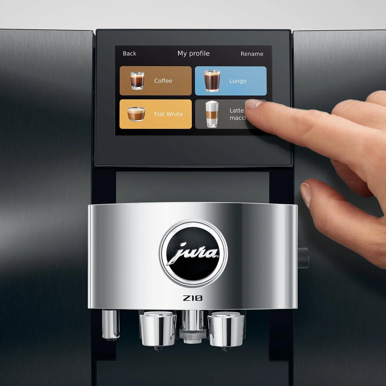 A close-up of a Jura Z10 coffee machine with a human hand touching the touchscreen display, set against a dark metallic background.