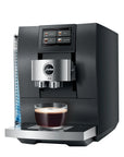 A sleek black and silver Jura espresso machine with a digital touch screen, shown with a cup of espresso on the drip tray against a white background.