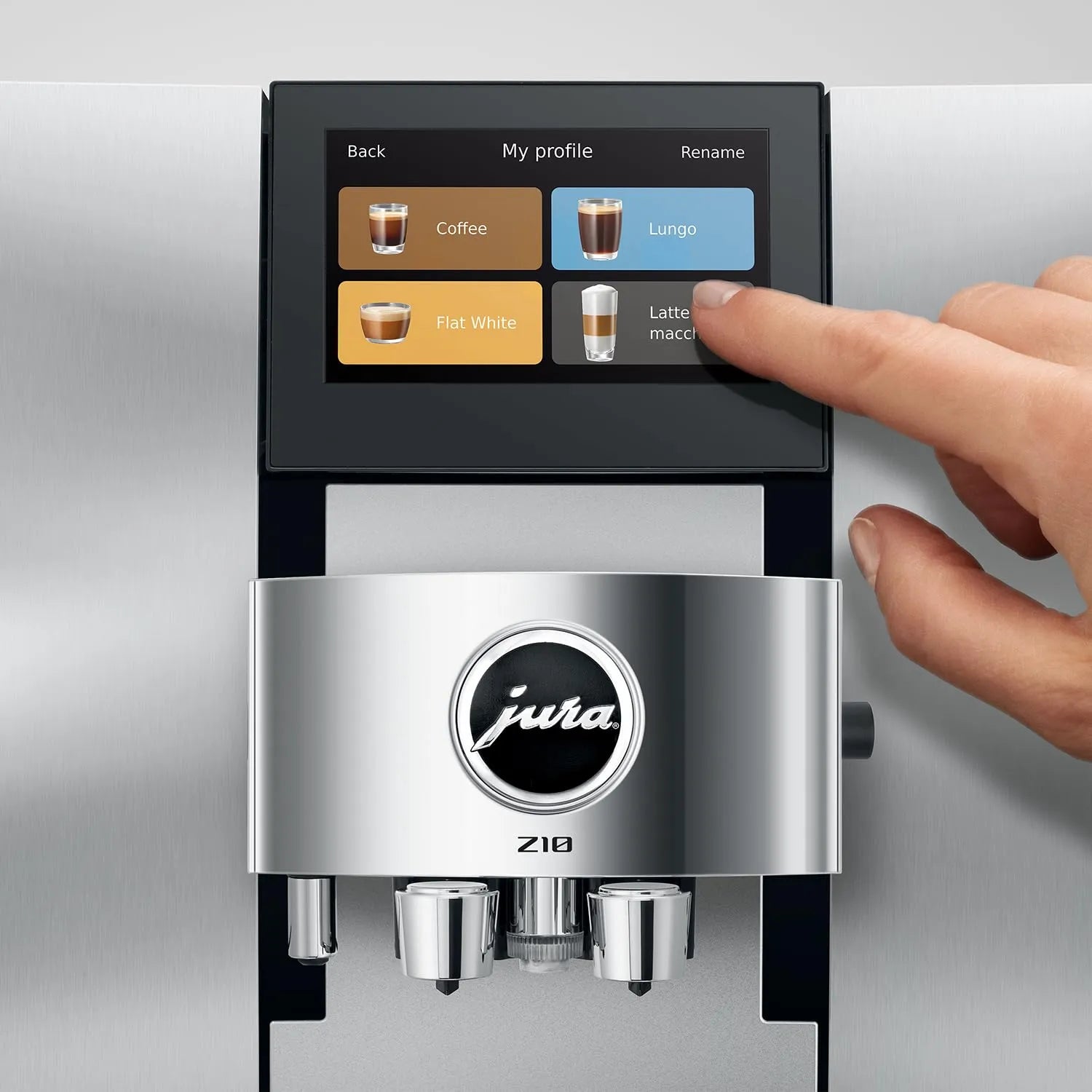A close-up of a Jura Z10 coffee machine with a human hand touching the touchscreen display, set against a brushed stainless steel background.