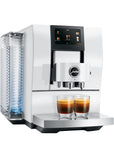 Diamond White Jura espresso machine with two creamy coffees in glass cups on stand displayed on a white background