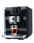 Diamond Black Jura espresso machine with a creamy coffee in glass cup on stand displayed on a white background