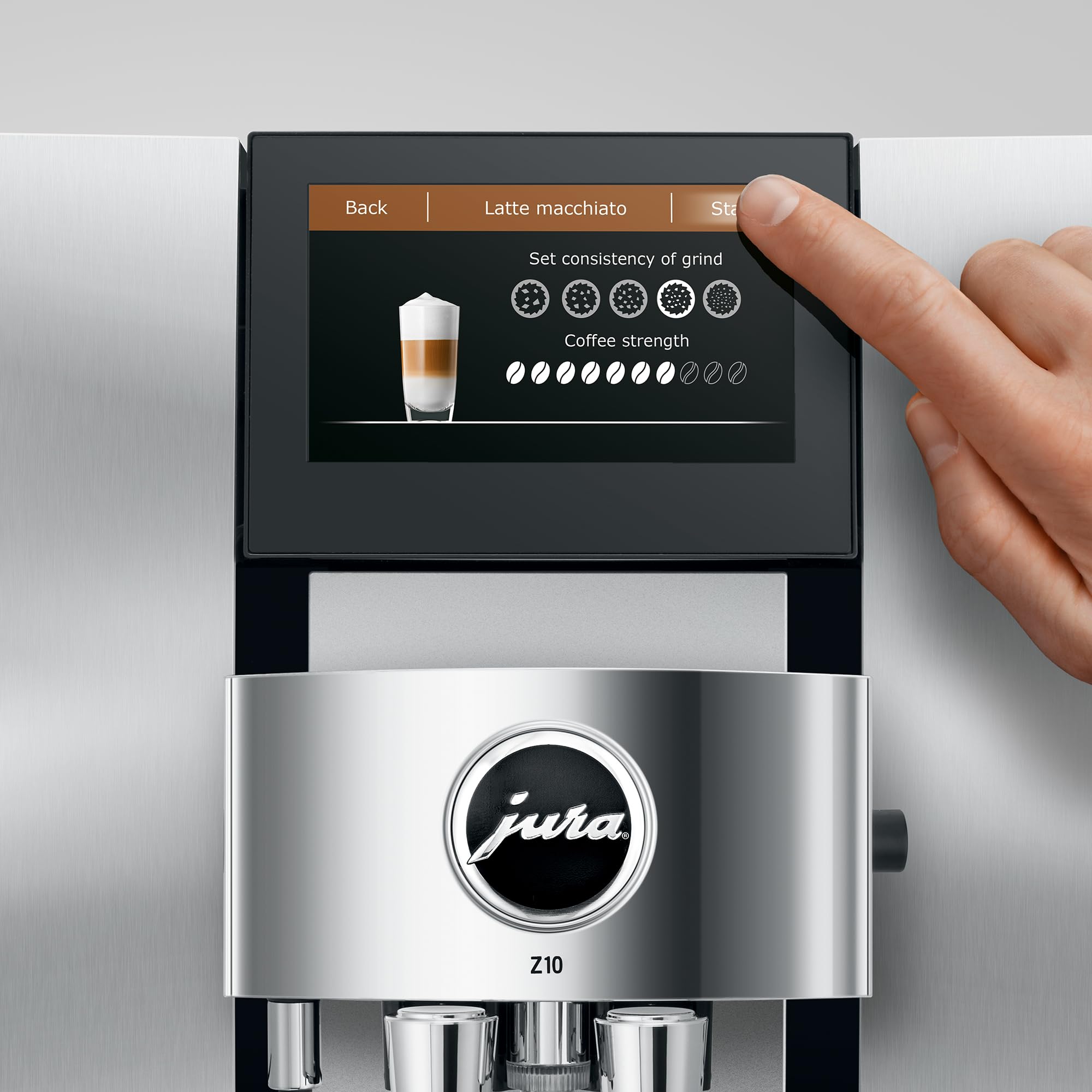 Close up of Aluminum White Jura espresso machine with a finger pressing buttons on a touchscreen coffee selection