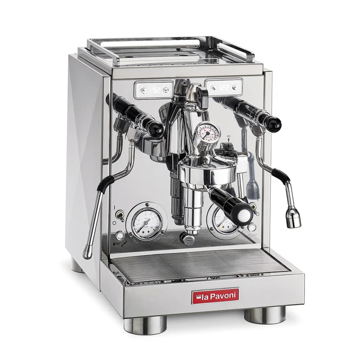 A professional espresso machine by la Pavoni, featuring a polished stainless steel body, two analog pressure gauges, a central portafilter holder, and a red brand logo plate on the front.