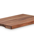 A rectangular wooden cutting board with a dark brown finish and a curved handle cut on one end, shown on a plain white background.