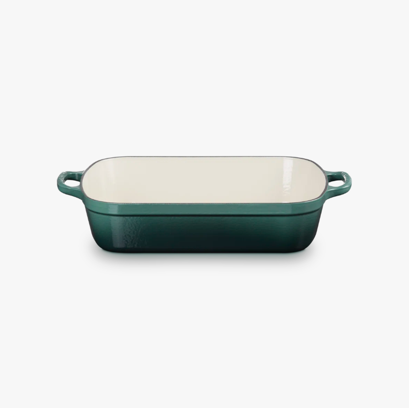 Green rectangular baking dish with cream interior on a white background