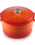 Orange enameled cast iron Dutch oven with a lid on a white background