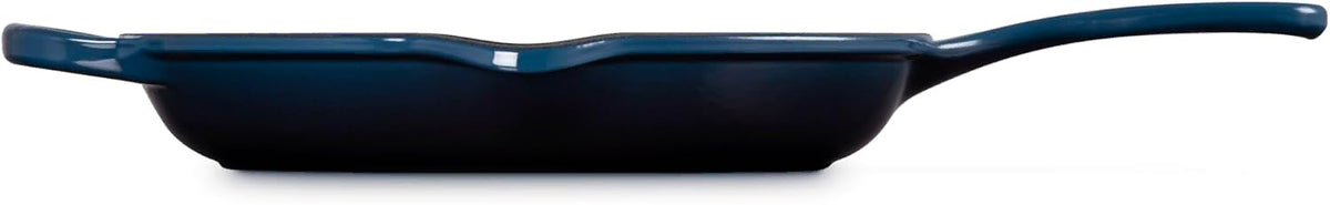 Side view of a dark blue cast iron skillet with a long handle, shown from a side profile view against a white background.