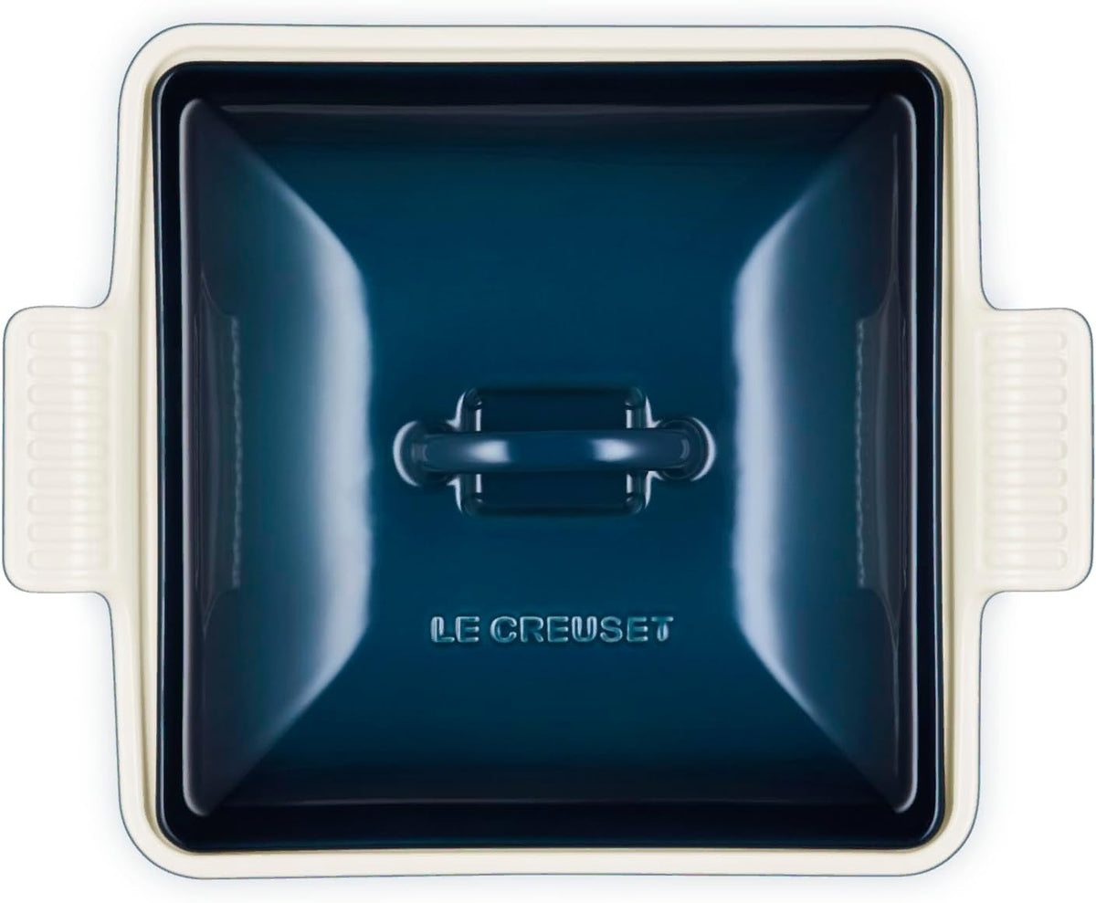 Top view of a dark blue Le Creuset 2.5 qt (9-Inch) Stoneware Heritage Covered Square Casserole displayed on a white background
