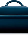 Side view of a dark blue enameled cast iron casserole dish with a lid, featuring cream-colored handles on the sides, shown against a plain white background.