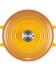 Top-down view of a Le Creuset round enameled cast iron pot or Dutch oven with yellow-orange exterior and bright yellow handles, shown on a plain white background.