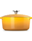 A yellow enameled cast iron Dutch oven with a matching lid and side handles, featuring a silver metal knob on top, set against a plain white background.
